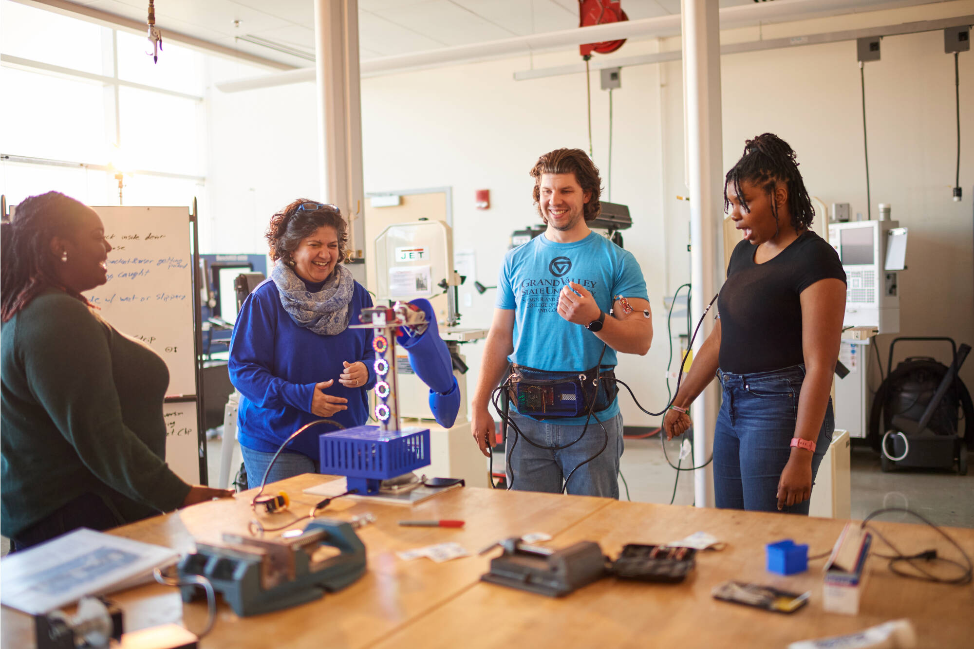 Professor Samhita Rhodes guiding students in a robot arm demonstration